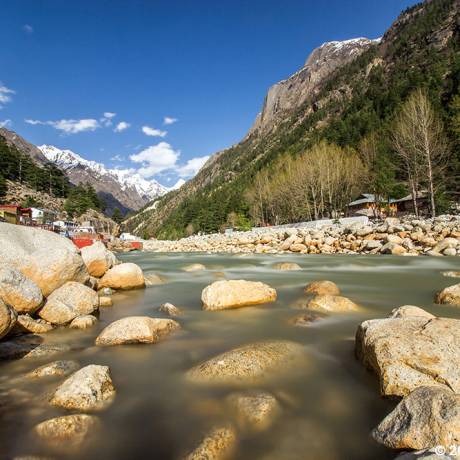 Ganga river flowing through the Gangotri(the origin of the river Ganga) and temples situated on the bank of Ganga river.