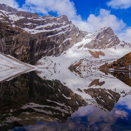 Reflection of snow covered mountains on Hemkund Lake at Hemkund sahib, Chamoli.